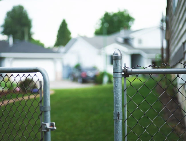 Photo showing an open gate at a suburban house in the United States - the standing open gate symbolizes the open-nature of lack security on the web and how businesses should give careful consideration to securing their website.