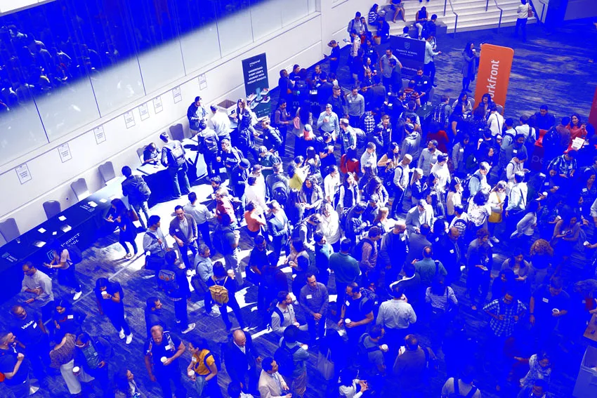 Photo shows a tradeshow hosted by a professional Association in 2023 with many event attendees gathered in a crowd